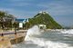 Thailand: Heavy seas smash against Prachuap Khiri Khan's promenade with Khao Chong Krajok (Mirror Mountain) and Wat Thammikaram in the background